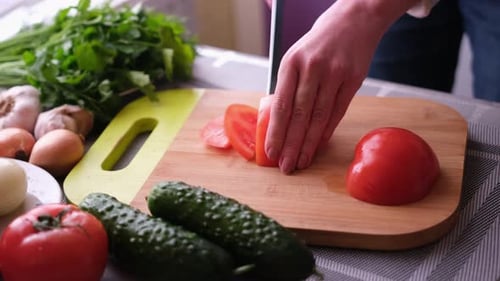 Slicing Fresh Tomato in Kitchen for Salad