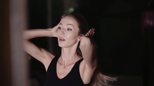 Woman Puts Hair Up in Ponytail at Night