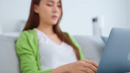 Woman With Laptop Rubbing Eyes on Sofa
