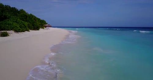 Beautiful birds eye travel shot of a white sandy paradise beach and aqua blue water background in vi