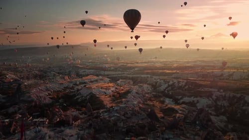 Aerial Drone Landscape of Dusk Over Cappadocia Limestone Valley and Hot Air Balloons Moving in Sky
