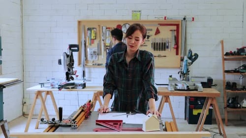 Pretty Carpenter workers woman working on workshop table in in wood workshop
