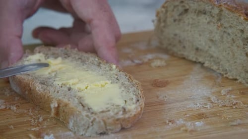 Fresh Bread Buttered on Cutting Board, Close Up
