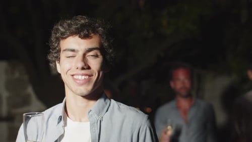 Smiling Young Adult with Champagne at Nighttime Party