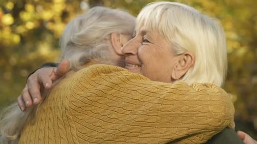 Senior Women Friends Embracing in Autumnal Park