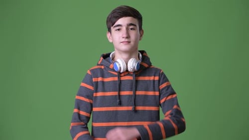 Joven guapo adolescente iraní sobre fondo verde