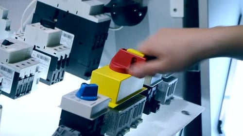 Hand Operating Electrical Switches on Panel