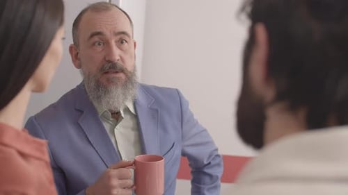 Business Discussion Between Three Colleagues at Workplace