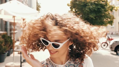 Stylish Woman with Curly Hair Smiling in City