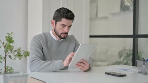 Young Man Using Tablet While Sitting in Office