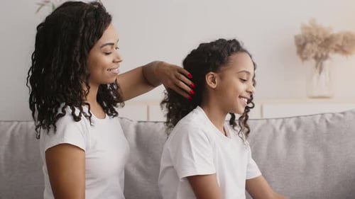 Woman Brushing Child's Hair with Smile