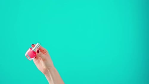 Hand Holding Pink Nail Polish Bottle Close Up