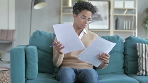 Young Adult Reviewing Documents on a Sofa