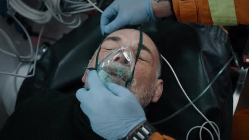Crop Paramedics met un respirateur sur un patient