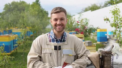 Smiling Beekeeper in Protective Suit Poses Outdoors