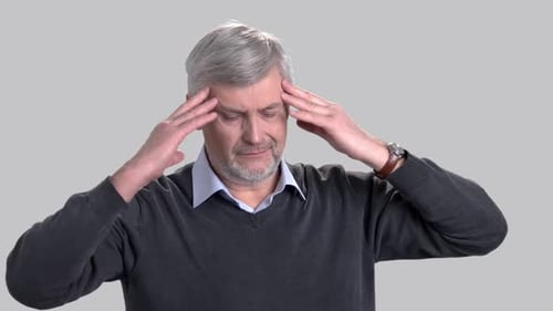 Reifer kaukasischer Mann, der unter Kopfschmerzen leidet.