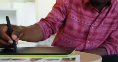 Man Uses Stylus and Tablet for Digital Art