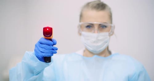 Doctor Measuring Patient Temperature at Health Care Clinic