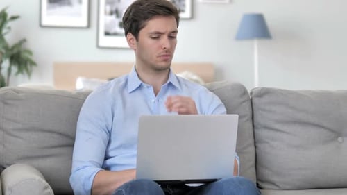 Young Adult Working on Laptop at Home