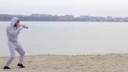 Man in Tracksuit Boxing on a Beach