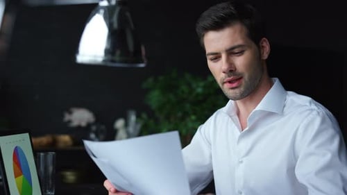 Young Adult Reviews Business Data in Office