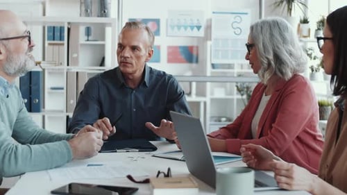 Professionals Collaborate During a Meeting in Modern Office