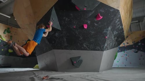 Young Man Rock Climbing on Indoor Wall