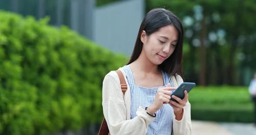 Woman Using Smartphone Outdoors in Urban Setting