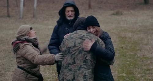 Family Embracing Outdoors on Overcast Day