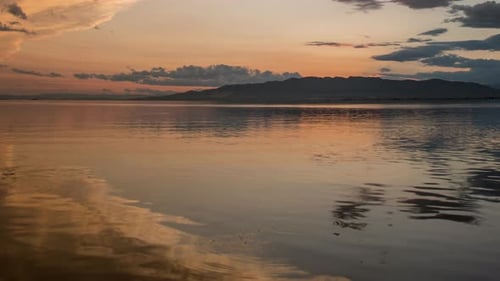 Serene Water Reflects Warm Golden Hour Sky
