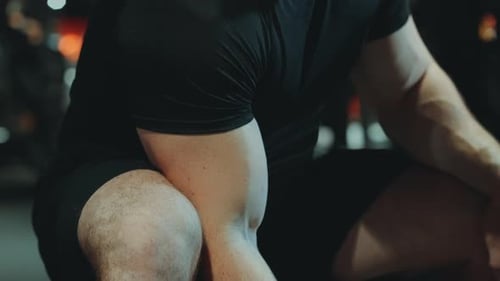 Biceps of Man Lifting Dumbbell in Gym