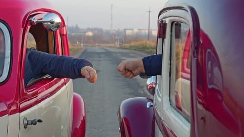 Two Drivers Play Rock Paper Scissors Between Cars Before a Race or Competition