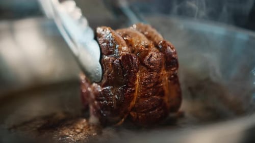 Close-up of a filet mignon being cooked in a frying pan