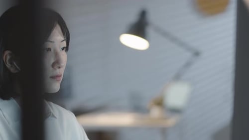 Focused Businesswoman Working on Computer in Dark Office