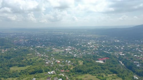 Aerial Drone View of a Big Village in a Mountain Valley Against a Cloudy Sky
