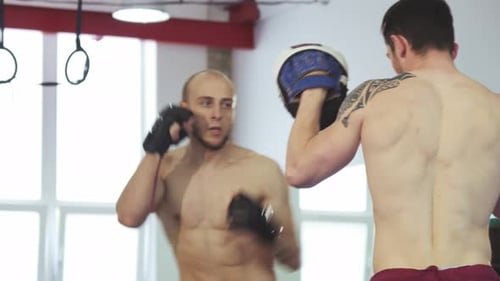 Jovem treinando habilidades de boxe com seu parceiro de treino