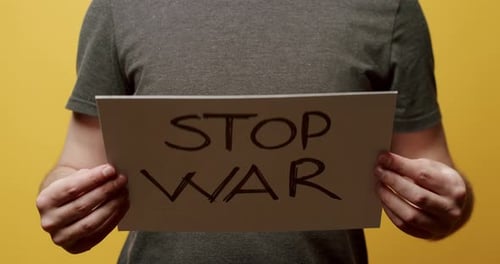 Person, die ein Whitepaper mit der Nachricht Stop War in der Hand hält. Wir wollen keine Kriegsbotschaft.