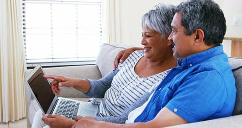 Senior Couple Using Laptop on Couch