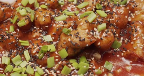 Close Up of Fried Chicken with Sauce and Seeds