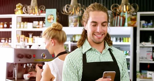 Smiling Employee Checks Phone in Cafe Setting