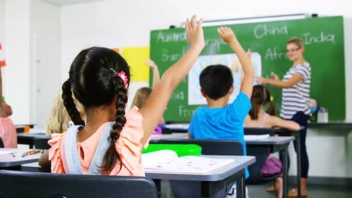 School kids raising hand in classroom