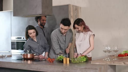 Friends Cooking and Preparing Food Together in Kitchen