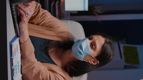 Femme d'affaires bourreau de travail avec masque facial contre Covid19 travaillant dans un bureau de démarrage