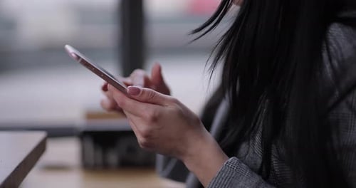 Woman Hands Uses Smartphone in a Cafe