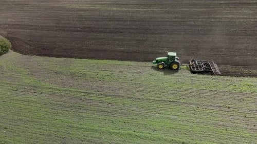 Un tracteur laboure la terre sur un champ non cultivé