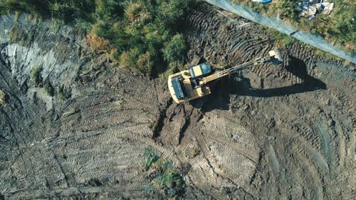 Vue aérienne de l'ouvrage supérieur d'une excavatrice qui déblaie et nivelle la zone