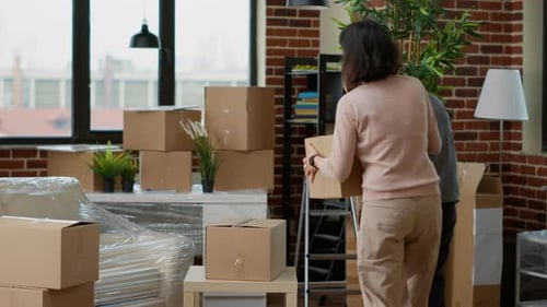 Couple Unpacking Boxes in New Apartment