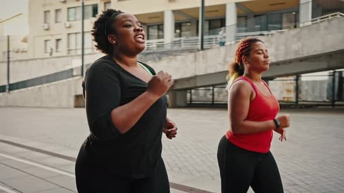 Women Running Together on an Urban Street