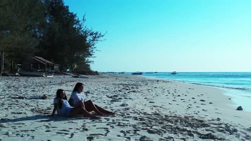 Pretty smiling ladies on vacation spending quality time at the beach on paradise white sand and blue