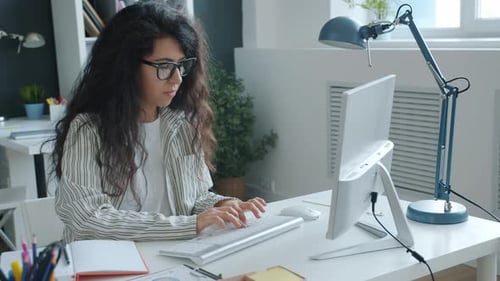 Young Business Lady Working with Computer Typing Concentrated on Project in Office